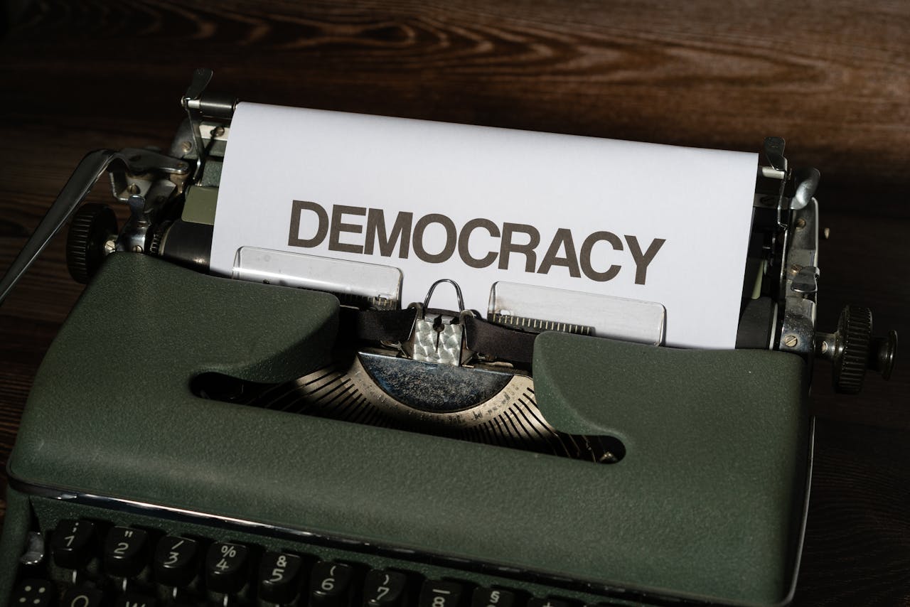 Close-up of a vintage typewriter with the word 'Democracy' on paper, emphasizing freedom and expression.